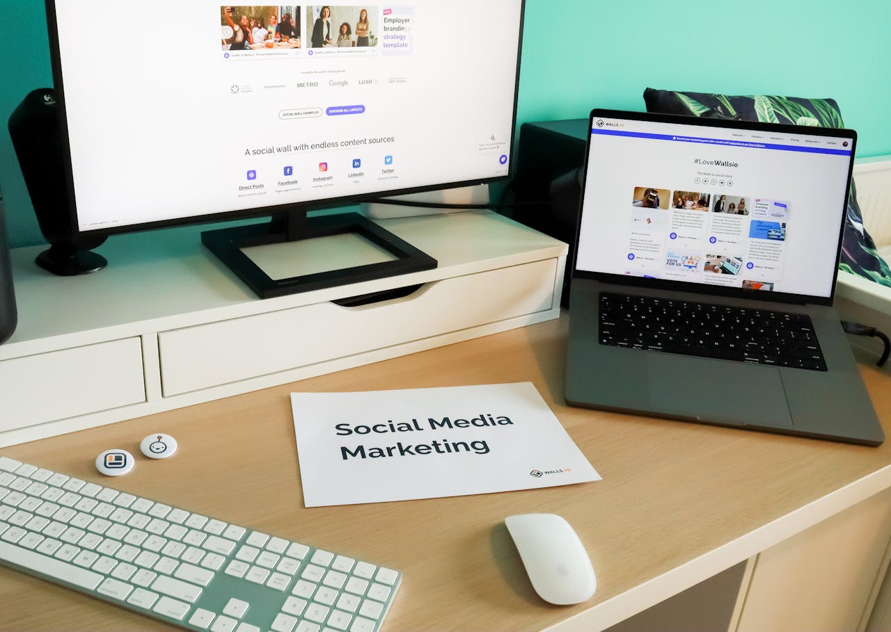 Workspace setup showcasing tools and resources for social media marketing in Pakistan, including monitors, laptops, and materials.